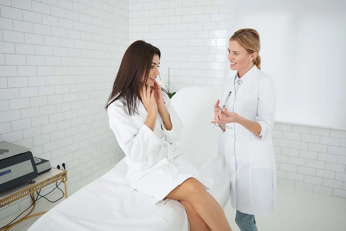 Caucasian patient talking to a patient care coordinator or a plastic surgeon about her saddle nose deformity or the risk of complications of this surgical technique (rib graft rhinoplasty).
